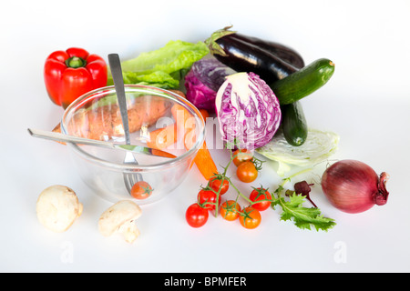 Fresh vegetables and an empty salad bowl. Whole uncut salad ingredients on white background Stock Photo