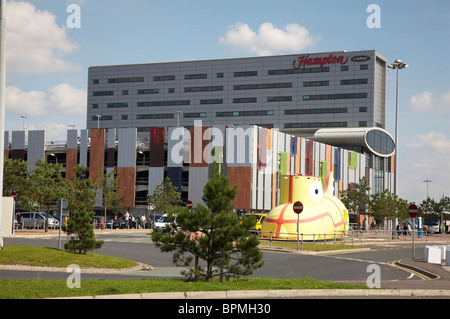 Hampton by Hilton hotel with Yellow submarine and multistorey carpark at John Lennon Airport Liverpool UK Stock Photo