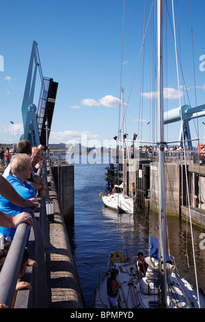 Yachts entering lock gates at Cardiff bay barrage from penarth marina en route to the Bristol channel. Stock Photo