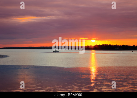 Sunset over the Isle of Anglesey across the Menai Strait at sundown from Caernarfon, Gwynedd, North Wales, UK, Britain Stock Photo