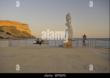 Fisherman memorial and people on the seaside promenade and cliffs in the evening light, Cassis, Cote d´Azur, Bouches-du-Rhone, P Stock Photo