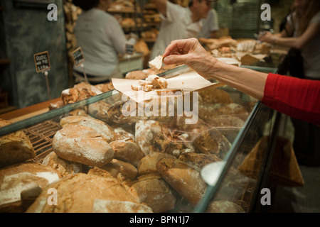 A visitor samples bread at Eataly artisanal Italian food and wine marketplace in New York Stock Photo