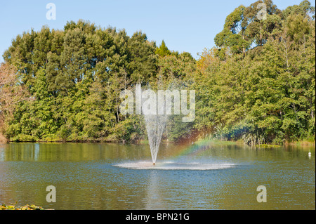 Fountain with a small rainbow in Gilmour Reserve, a local park close to SH2 in Waihi, New Zealand Stock Photo
