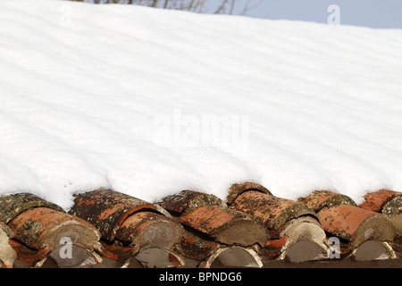 aged clay roof tiles snowed under snow architecture detail Stock Photo