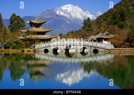 Pagoda and bridge reflected on Black Dragon Pool in front of Jade Dragon Snow Mountain, Lijang, Yunnan, China Stock Photo