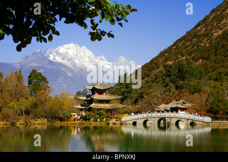 Pagoda and bridge reflected on Black Dragon Pool in front of Jade Dragon Snow Mountain, Lijang, Yunnan, China Stock Photo