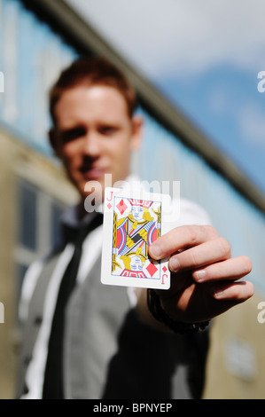 young white male magician performing card tricks outside Stock Photo