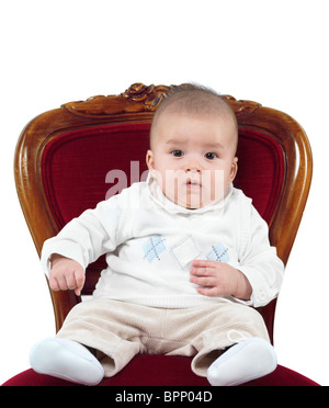 Humorous photo of a four month old baby boy sitting in a chair like a king on a throne. Isolated on white background. Stock Photo