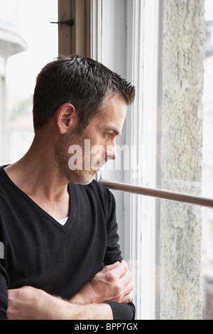 Man looking out window Stock Photo