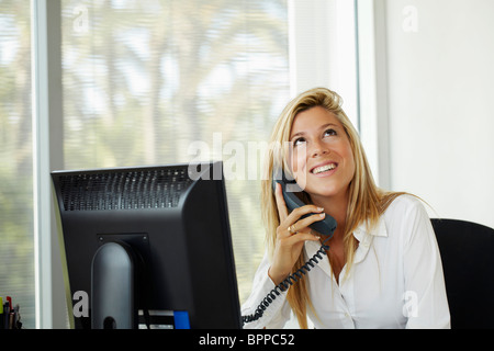 Female office worker on phone Stock Photo