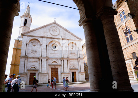 ITALY, Tuscany, Pienza, Val D'Orcia The Duomo in Piazza Pio II seen through an arch with tourists walking in the square. Stock Photo