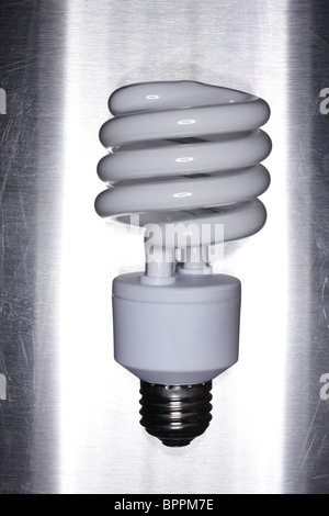 Compact Florescent light bulb on metal surface Stock Photo
