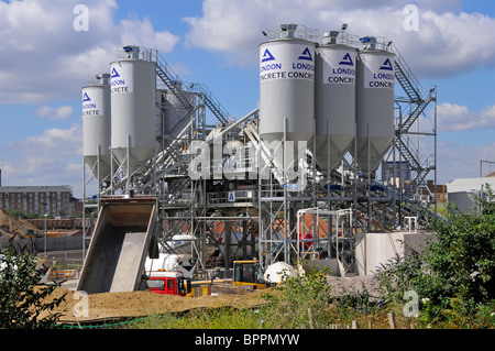 London Concrete ready mix industrial site distribution depot tall cement silos aggregate storage & mixer delivery lorry trucks East London England UK Stock Photo