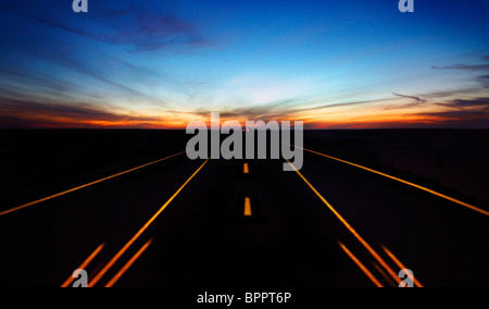 Night highway with dramatic sky & car lights in motion Stock Photo
