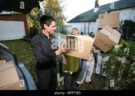 Image shows a happy family moving house, loading cardboard boxes together into their car. Photo:Jeff Gilbert Stock Photo