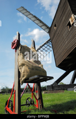 Sack of flour on an old trolley beside a windmill. Stock Photo