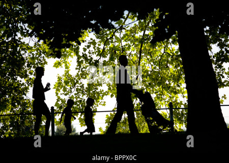 The outline of a family strolling in the Napoleon III Park in Vichy (France). Woman and man with children. Stock Photo