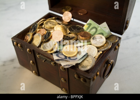 A treasure chest filled with money Stock Photo