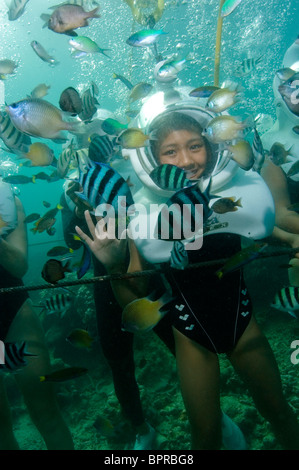 Young girl Sea Walking, looking at schools of fishes, profile, front view, Sapi Island, Sabah, Malaysia Stock Photo