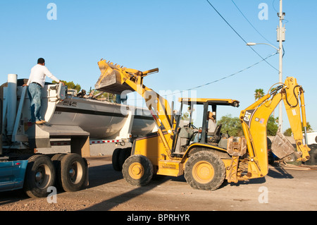 A backhoe is being used to remove debris from the demolition of  an old commercial building. Stock Photo