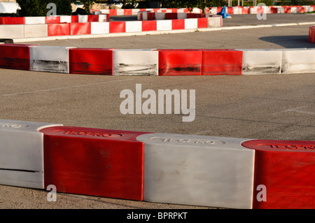 Red and white bollards at a go-kart race track Stock Photo