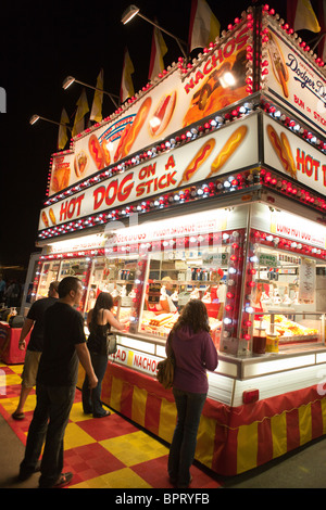 People wait in line at a hot dog on a stick stand at night, California Mid-State Fair, Paso Robles, California Stock Photo