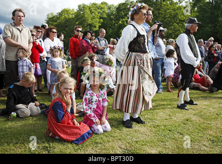 Spectators in country folk costumes on midsummer’s festival day. Naas castle estate, Sweden, Scandinavia. Stock Photo