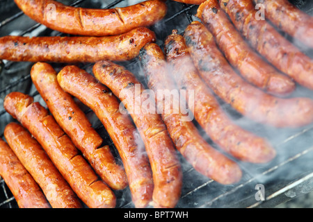 sausages being cooked on hot grill Stock Photo