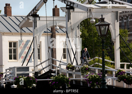 Old historic Rembrandtbrug Rembrandt bridge double drawbridge with cyclist, man on a bicycle, in Leyden, Leiden, The Netherlands Stock Photo