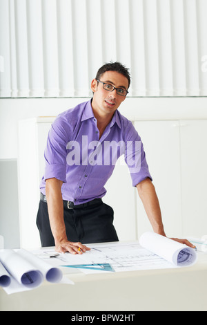 portrait of mid adult architect leaning on desk and looking at camera Stock Photo