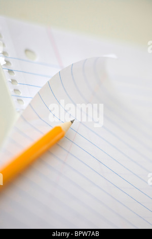yellow school pencil on lined note book paper Stock Photo
