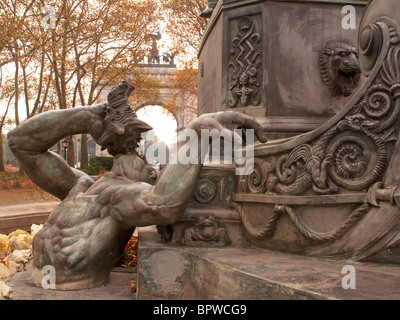 Bailey Fountain Brooklyn New York statue with close up of King Neptune  and fish frogs Grand Army Arch in background fall Stock Photo
