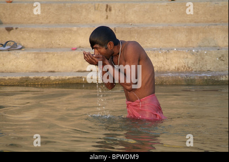 Man bathing in the holy waters of the Ganges River in Varanasi, India Stock Photo