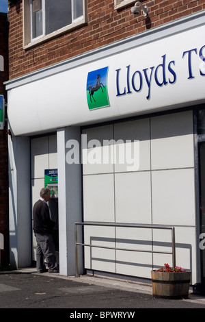 Man using LLoyds TSB Bank cashpoint Stock Photo