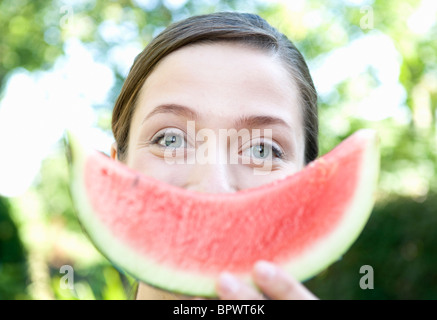 Woman holds up smiley water melon Stock Photo