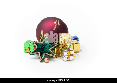 A selection of pretty Christmas ornaments, green star, red glass ball and foil wrapped boxes. Stock Photo