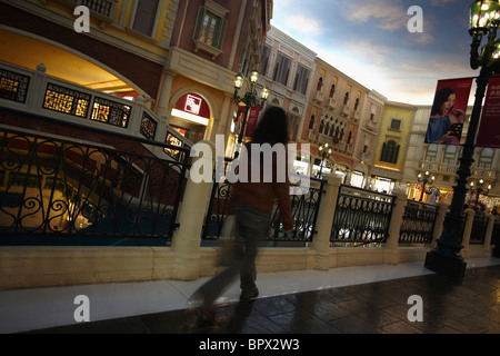 Woman walking along canal in Grand Canal Shoppes shopping mall in the Venetian hotel, Taipa, Macau, China Stock Photo