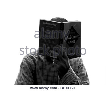 Silhouetted man reading book Stock Photo