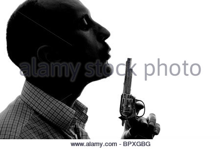 Silhouetted man blowing smoke from toy gun Stock Photo