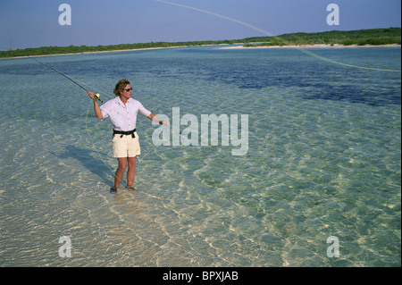 A fly-fisherman casts to a bonefish in the Bahamas. Stock Photo