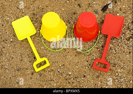 Colourful plastic bucket and spade on a beach. Stock Photo