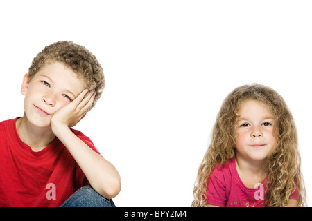 caucasian little boy bored and girl smiling portrait isolated studio on white background Stock Photo