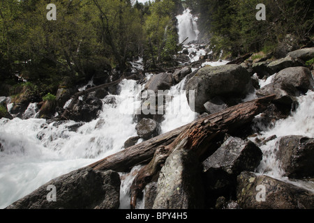 De Ratera waterfalls and alpine forest on Pyrenean Traverse track in the Sant Maurici National Park Pyrenees Spain Stock Photo