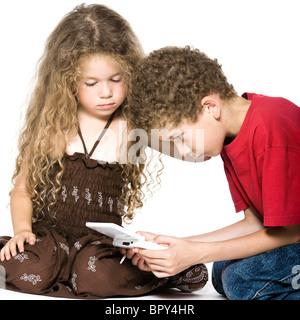 caucasian little boy and girl playing console game isolated studio on white background Stock Photo