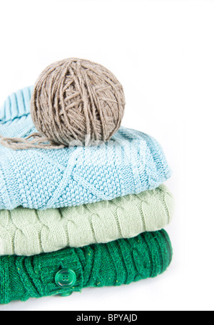 Pile of sweaters and ball of yarn Stock Photo