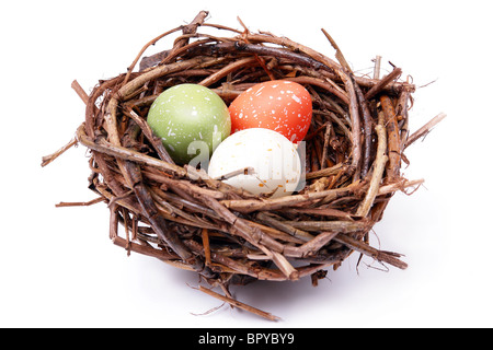 Three speckled eggs in bird's nest over white background Stock Photo