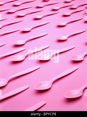 plastic pink spoons on pink background Stock Photo