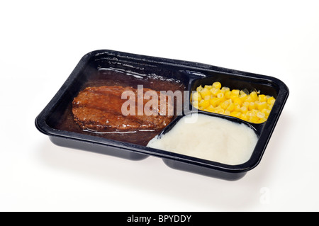 A cooked microwaved tv dinner, ready meal of salisbury steak, corn and mashed potatoes with gravy on white background, cutout. Stock Photo