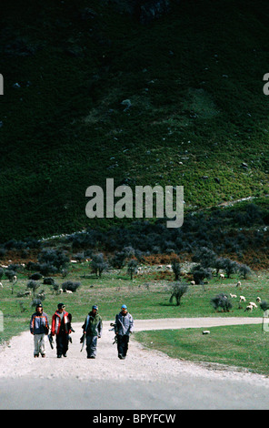 Snowboarders hiking down the road at the end of the day from Treble Cone, NZ Stock Photo