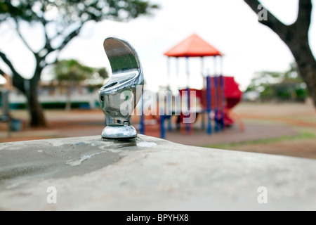 water fountain with a park and trees in background Stock Photo